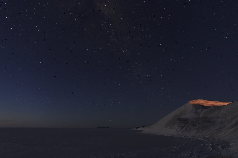 A view of the stars looking north from Hut Point. The next land north from here is New Zealand - over 2000 miles away. In this photograph you can still see a lingering glow on the horizon from the sun that set several hours earlier. 