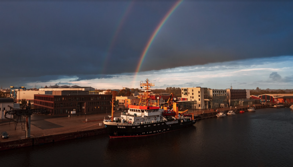 ship in port with rainbow