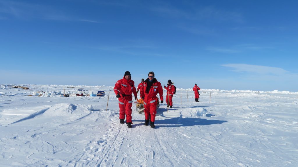 scientists in red walking on ice