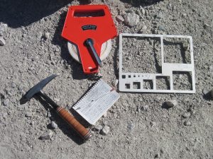 tape measure, gravelometer, rock hammer, and field notebook.