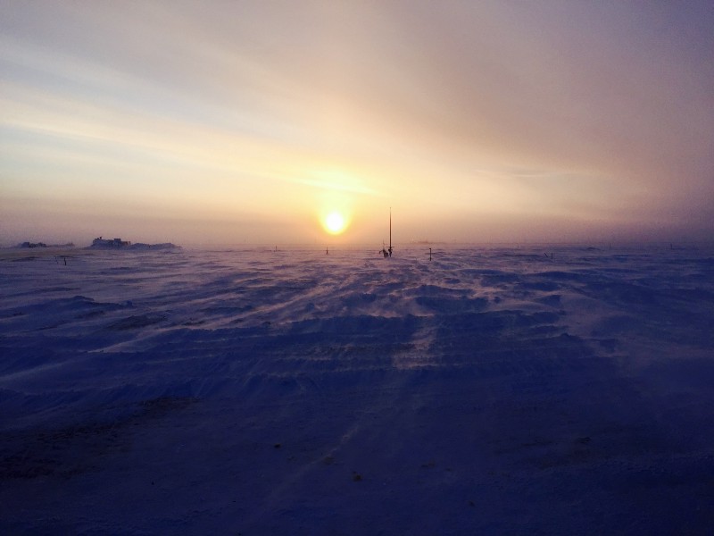The sun rises over a windy AMF-3 site. Note the wind blown snow over the surface. 
