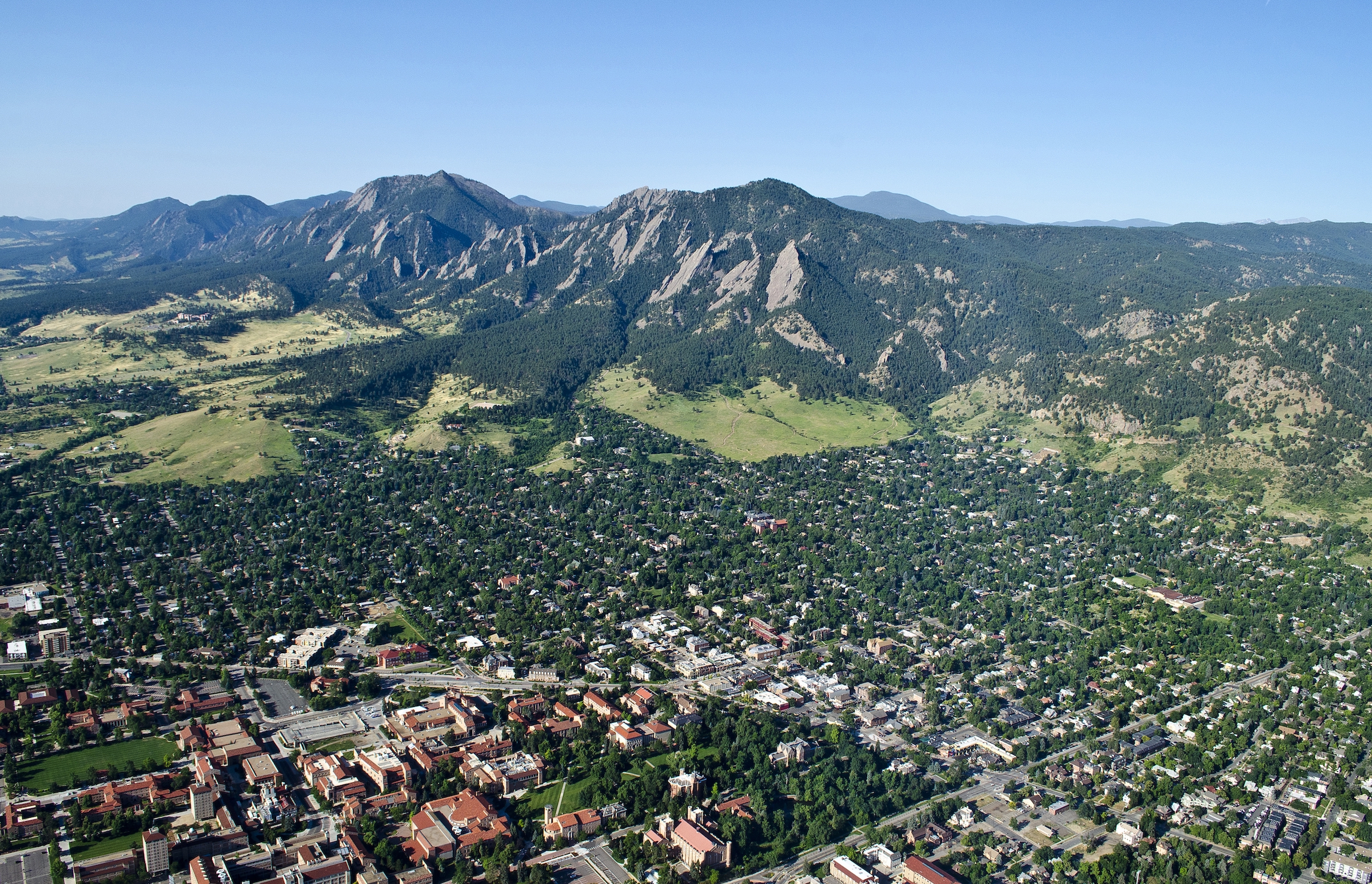 Blue sky, flatiron mountains, green foothills, and CU campus.